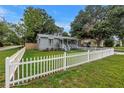 Cozy home featuring a white picket fence, grass lawn and colorful flowers at 300 33Rd N Ave, St Petersburg, FL 33704