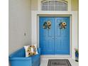 Inviting double front doors with sunflower decor, a matching bench, and a 'Welcome' mat at 30918 Burleigh Dr, Wesley Chapel, FL 33543