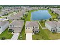 Aerial view of a well-planned community with a lake, showcasing homes with lush green yards at 30936 Summer Sun Loop, Wesley Chapel, FL 33545