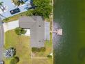 Aerial view of a home with a private dock on the water, showcasing lush greenery and a well-manicured lawn at 3226 Gardenia Dr, Hernando Beach, FL 34607