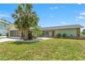 Charming single-story home featuring a well-maintained lawn, stone accents, and mature palm tree at 3226 Gardenia Dr, Hernando Beach, FL 34607
