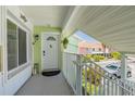 Charming front entrance featuring a covered porch, white door with decorative window, and vibrant green accents at 3595 41St S Ln # L, St Petersburg, FL 33711