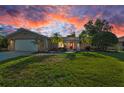 Charming home with a well-manicured lawn, a red door, and mature landscaping at 395 Forest Park Rd, Oldsmar, FL 34677
