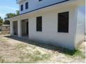 Side view of a modern home with dark-trimmed windows, columns, and a stucco finish at 4101 W Mango Ave, Tampa, FL 33616