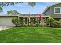 Well-kept front yard with lush lawn and flowering plants adding curb appeal at 4204 Northwind Ln, Tampa, FL 33624