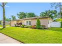 Attractive home featuring a manicured lawn, mature landscaping, and a combination of siding and stone accents at 4220 Woodlark Dr, Tampa, FL 33624