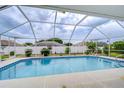 A refreshing screened-in swimming pool with a white frame, perfect for outdoor relaxation and enjoyment at 4368 Las Palmas Ave, Spring Hill, FL 34606