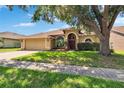 Charming tan home with a two-car garage, well-manicured lawn, and a front yard featuring lovely palm trees at 4418 River Overlook Dr, Valrico, FL 33596