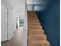 Carpeted staircase with white railing and contrasting blue accent wall at 500 New York Ave # 23, Dunedin, FL 34698