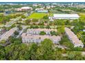 An aerial view of a condo community surrounded by trees, lawns, and the city in the background at 5052 Sunridge Palms Dr # 102, Tampa, FL 33617