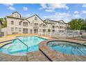 A community pool and hot tub are surrounded by a white fence and the condo building at 5052 Sunridge Palms Dr # 102, Tampa, FL 33617