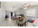 Bright and open-concept living and dining area with tile flooring, ceiling fans, and ample natural light at 7124 Barclay Ave # A, Spring Hill, FL 34609