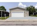 Attached two-car garage featuring a white door with an ample freshly painted driveway at 8471 Fantasia Park Way, Riverview, FL 33578