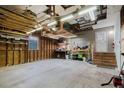 Spacious garage with exposed wood beams, fluorescent lighting, and ample storage potential at 8471 Fantasia Park Way, Riverview, FL 33578