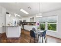 Bright kitchen and eat-in dining area with white cabinets, stainless appliances, and hardwood floors at 892 Crestridge Cir, Tarpon Springs, FL 34688