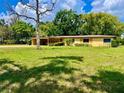 Charming single-story home features a well-manicured front yard with mature landscaping and a covered front porch at 10308 Fore Dr, Tampa, FL 33612