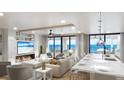 Bright, open living space with a fireplace, kitchen island, and ocean views through floor to ceiling windows at 14048 Gulf Blvd # 201, Madeira Beach, FL 33708