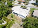 Aerial view of the house's back exterior featuring a covered patio and a yard surrounded by lush foliage at 1598 Brookside Blvd, Largo, FL 33770