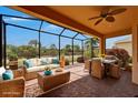 Inviting screened patio with wicker furniture and relaxing outdoor dining area overlooking the lush backyard at 1643 Emerald Dunes Dr, Sun City Center, FL 33573