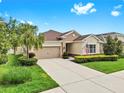 Inviting one-story home with a manicured lawn, a two-car garage, and a welcoming entrance at 17610 Buckingham Garden Dr, Lithia, FL 33547