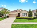 Charming one-story home with a well-manicured lawn, a two-car garage, and inviting curb appeal at 17610 Buckingham Garden Dr, Lithia, FL 33547