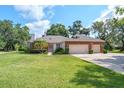 Charming brick home featuring a two-car garage, manicured lawn, and mature landscaping at 1815 Durant Rd, Valrico, FL 33596