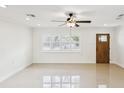 Bright living room featuring tile floors, a ceiling fan, and natural light from large window at 2016 Cove Dr, Largo, FL 33774