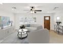 Bright living room boasts a ceiling fan, neutral tones, and floods of natural light at 2016 Cove Dr, Largo, FL 33774