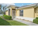 Screened in entry way with lush, green landscaping and a concrete path at 2218 Brookfield Greens Cir # 82, Sun City Center, FL 33573