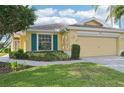 Close up of the home's front exterior and beautiful landscaping with a two-car garage at 2218 Brookfield Greens Cir # 82, Sun City Center, FL 33573