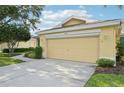 Attached two-car garage with a concrete driveway and well manicured lawn with garden at 2218 Brookfield Greens Cir # 82, Sun City Center, FL 33573