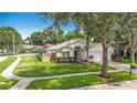 Attractive home with manicured lawn, mature trees, and neighborhood street view at 2601 Brookville Dr, Valrico, FL 33596