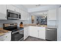 Efficient kitchen featuring granite countertops, stainless appliances, and convenient pass-through at 340 Causeway Blvd # 104, Dunedin, FL 34698