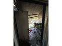 View of a fire-damaged back patio through a doorway, showing debris at 4010 Cedarlimb Ct, Tampa, FL 33614