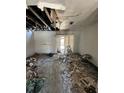 Damaged living room after a fire, showing exposed beams and debris throughout the room at 4010 Cedarlimb Ct, Tampa, FL 33614