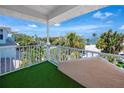 Second story balcony with synthetic grass and railing, offering scenic neighborhood views at 405 8Th N Ave, Tierra Verde, FL 33715