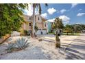 Single Gathering home with a well-manicured lawn, 2-car garage, and tropical landscaping at 405 8Th N Ave, Tierra Verde, FL 33715