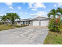 Well-maintained home boasting a spacious driveway, two-car garage, and attractive landscaping with vibrant flowers at 4210 Palm Dr, Punta Gorda, FL 33950