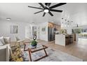 Bright living room featuring hardwood floors, modern furnishings, and an open concept design leading to the kitchen at 4210 Palm Dr, Punta Gorda, FL 33950