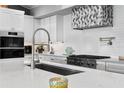 Modern kitchen with stainless steel appliances, a stylish range hood, and elegant countertops at 4649 Neptune Se Dr, St Petersburg, FL 33705