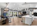Open-concept living area with modern lighting, hardwood floors, and sliding glass doors to outdoor patio and waterfront views at 4649 Neptune Se Dr, St Petersburg, FL 33705