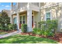 Inviting front porch with cozy seating and well-manicured landscaping leading to front door at 5401 Match Point Pl, Lithia, FL 33547
