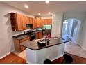Bright kitchen featuring wooden cabinets, stainless steel appliances, a breakfast bar, and hardwood flooring at 608 Black Lion Ne Dr, St Petersburg, FL 33716