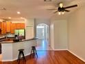 Open-concept living space with hardwood floors, recessed lighting, and a view of the kitchen and entryway at 608 Black Lion Ne Dr, St Petersburg, FL 33716