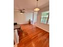 Spacious living area with hardwood floors, ceiling fan, and access to a screened lanai at 608 Black Lion Ne Dr, St Petersburg, FL 33716