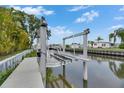 Private boat lift on a canal, surrounded by lush greenery and waterfront homes at 6534 Simone Shores Cir, Apollo Beach, FL 33572