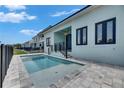 Outdoor swimming pool with patio, black metal safety fence, and a view of neighboring houses at 6534 Simone Shores Cir, Apollo Beach, FL 33572