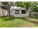 Beautiful backyard view with mature trees, grassy lawn, and a white privacy fence at 700 Starkey Rd # 1216, Largo, FL 33771
