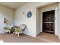 Inviting front porch features two wicker chairs with green cushions at 700 Starkey Rd # 1216, Largo, FL 33771