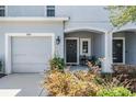 Close-up of townhome with charming covered front porch and a black front door at 7030 Summer Holly Pl, Riverview, FL 33578